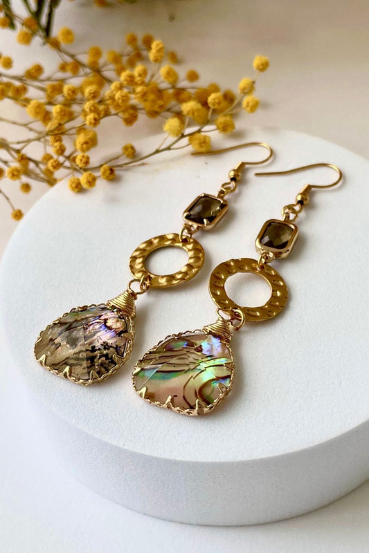 detalle de pendientes Tulúm dorados en acero inoxidable y cristal